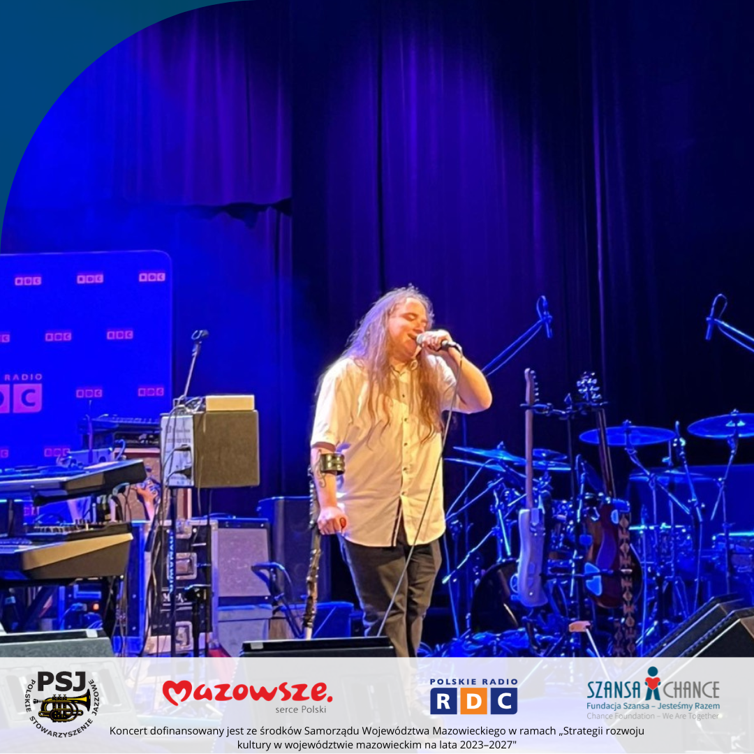 Piosenkarz stojący na scenie śpiewa.